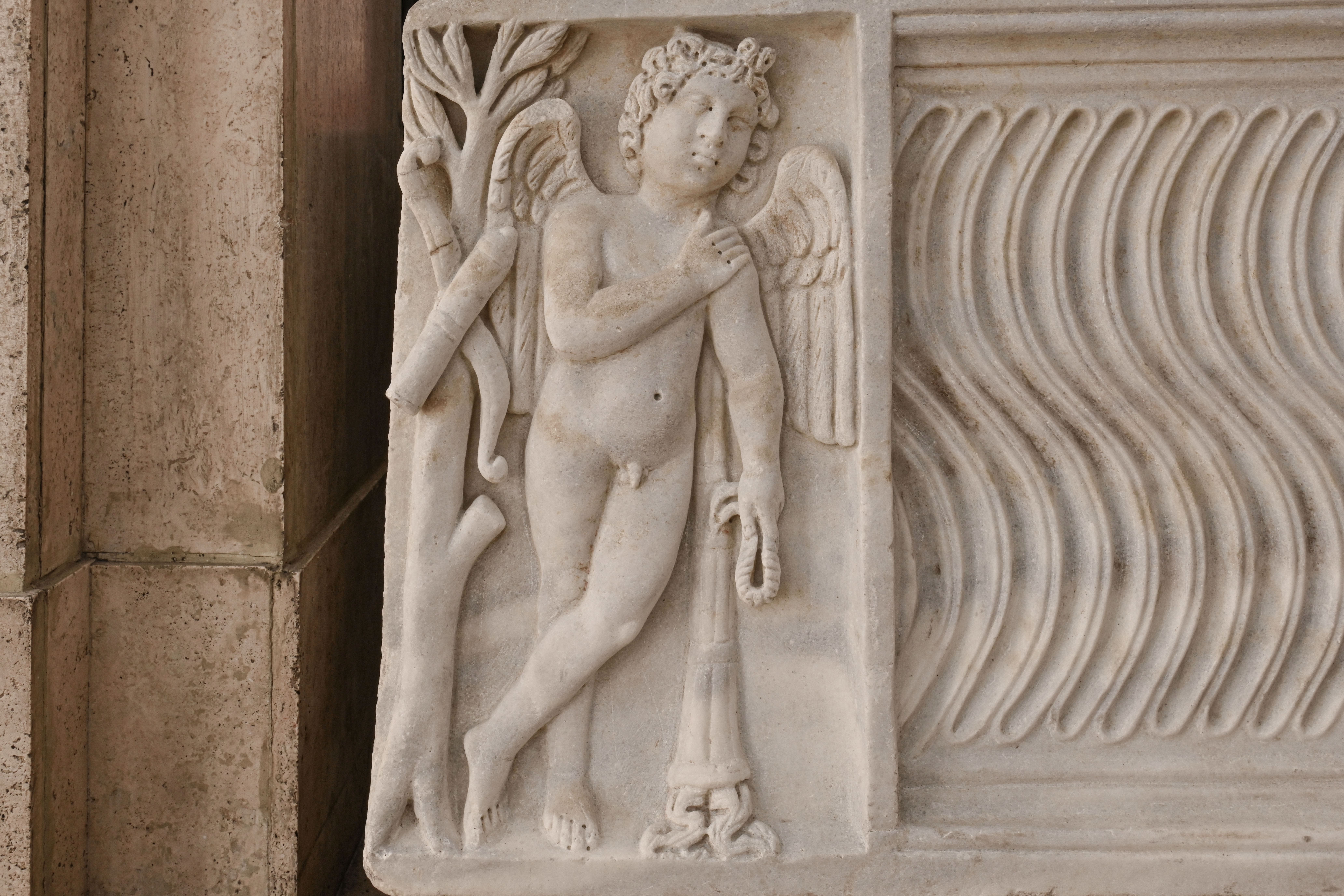 immagine del dettaglio sinistro del sarcofago strigilato con eroti funari