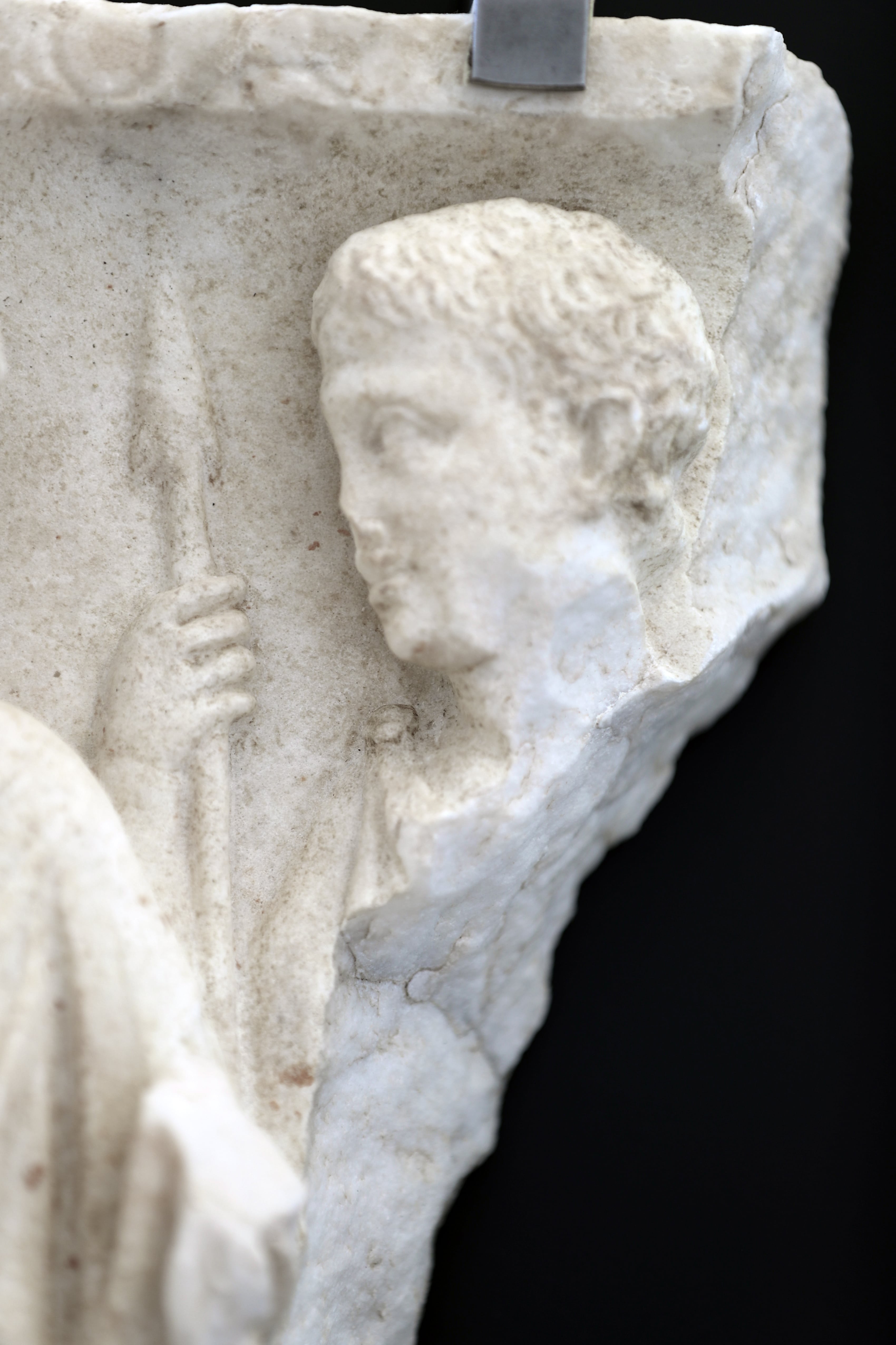 immagine di dettaglio della testa sinistra del rilievo con due figure maschili che rappresentano la partenza del guerriero