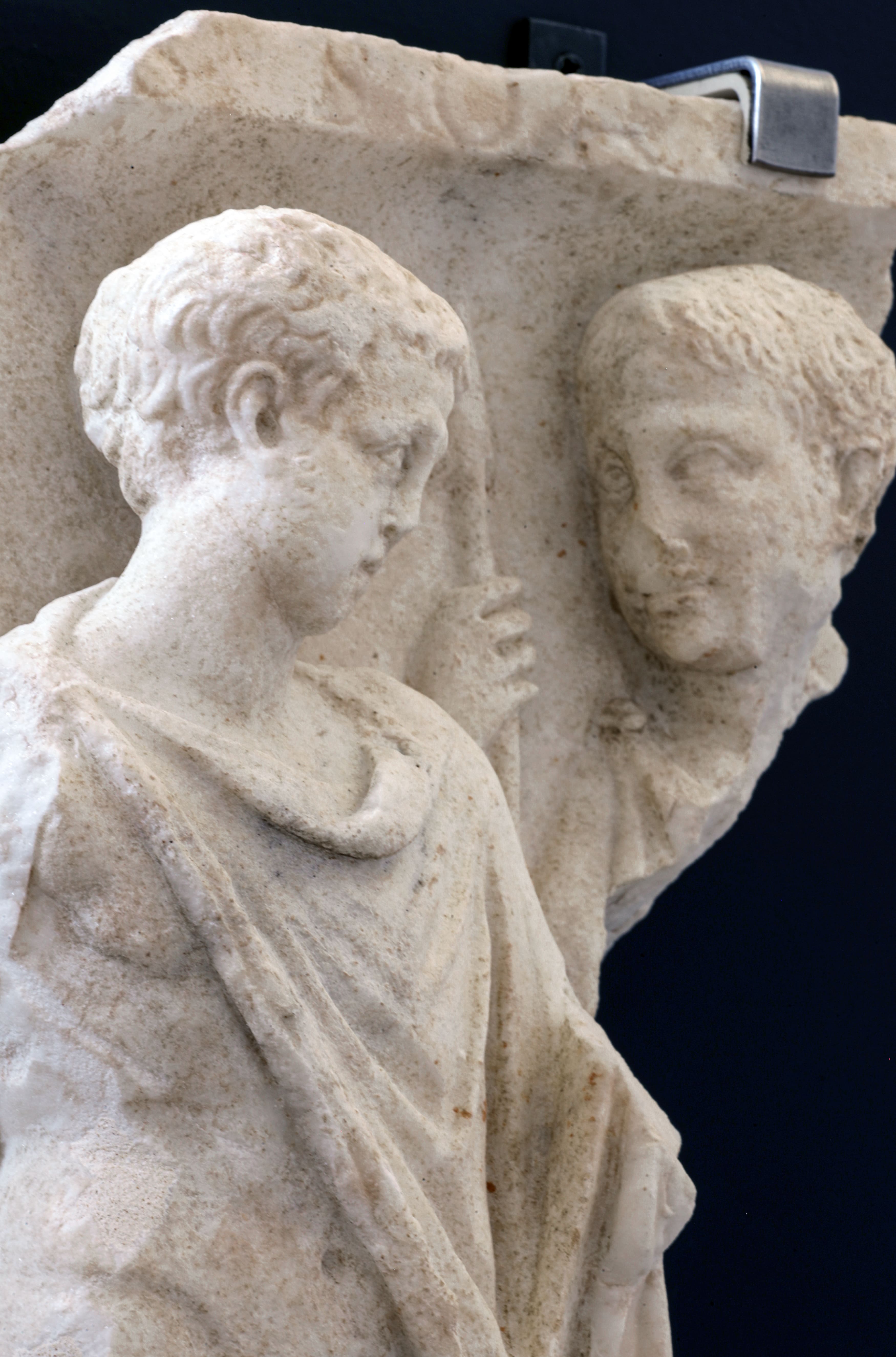 immagine di dettaglio delle teste del rilievo con due figure maschili che rappresentano la partenza del guerriero